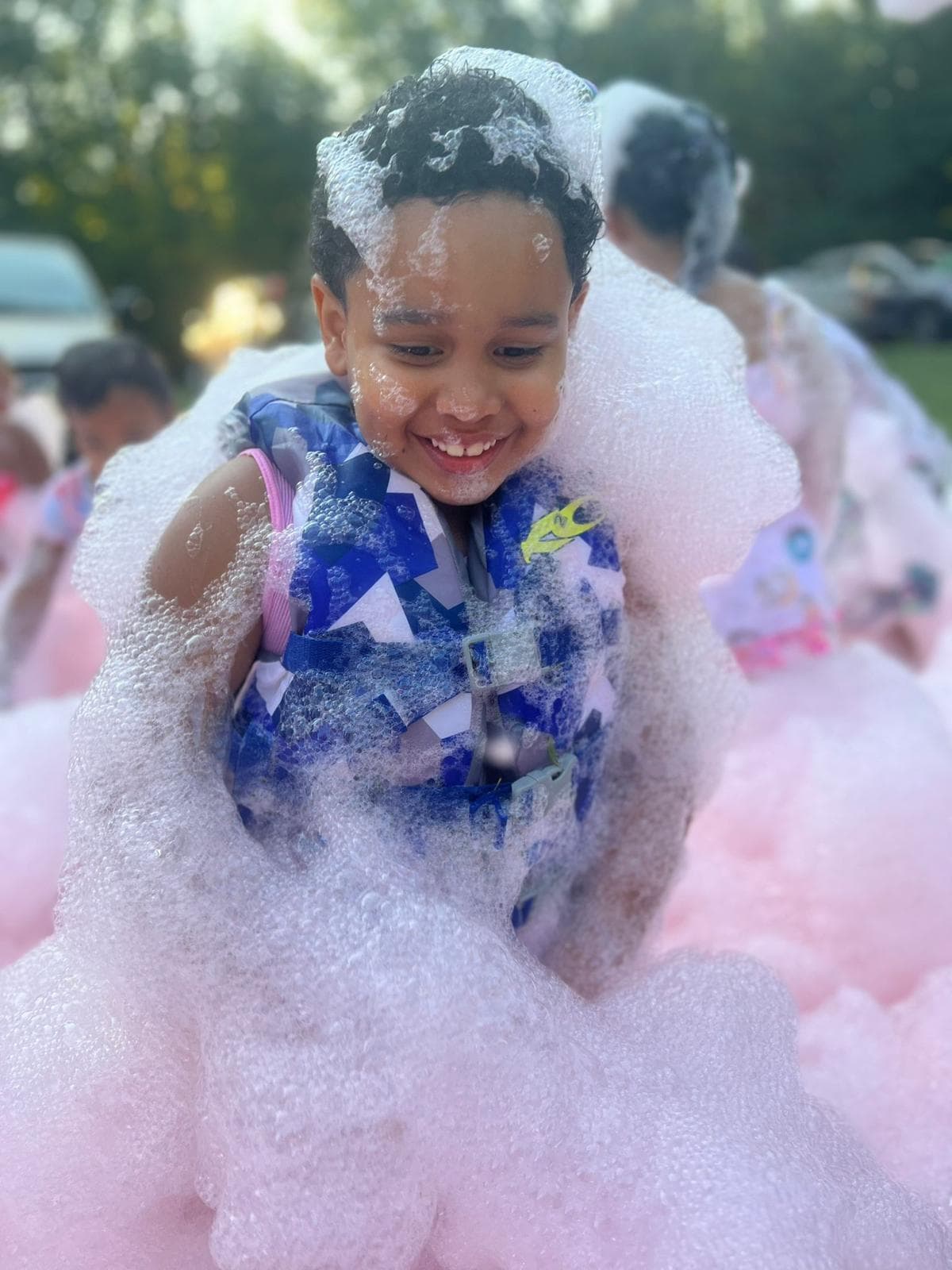 Happy child smiling covered in pink foam